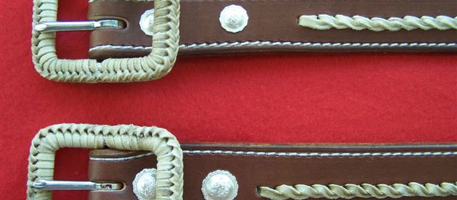 Matching pair of belts with rawhide accents and rawhide braided buckles.