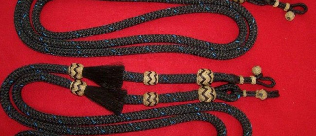 Braided nylon roping reins with horsehair tassels and rawhide knots and rawhide connectors.